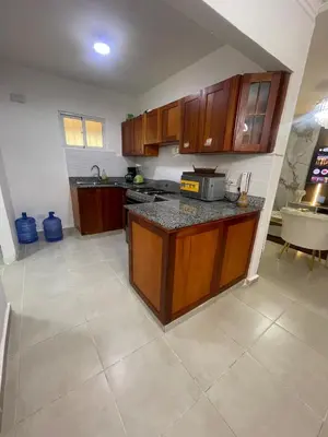 a kitchen with wooden cabinets and a counter top at Beautifull and Luxe Apartment 10 mn to the Int Airport in Los Paredones