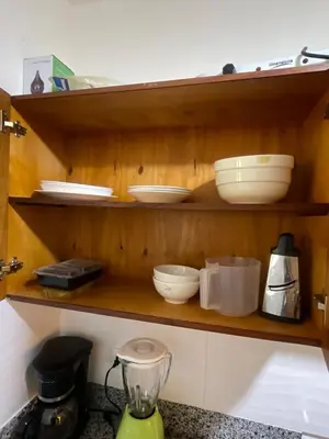 a shelf with bowls and other dishes on it at Beautifull and Luxe Apartment 10 mn to the Int Airport in Los Paredones