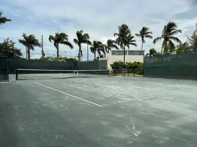 a tennis court with palm trees in the background at Portillo Residences, El Limon, Luxury Apartment in El Limón