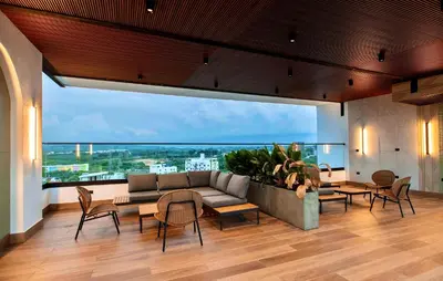 a living room with a couch and tables and a large window at Hermoso Alojamiento con Terraza y Jacuzzi en Santiago in Santiago de los Caballeros