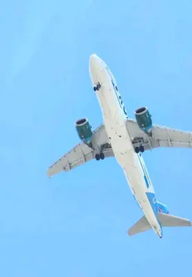 an airplane flying in the blue sky at Hermoso Alojamiento con Terraza y Jacuzzi en Santiago in Santiago de los Caballeros
