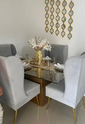 a dining room table with two chairs and a vase of flowers at El rincón de Sánchez in Moca