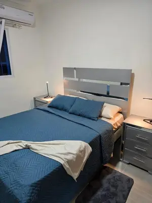 a bedroom with a blue bed and two night stands at Luxury Apartment in Boca Chica in La Julia
