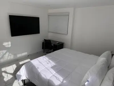 a bedroom with a bed and a desk and a television at Blue Oasis Luxury in Sosúa
