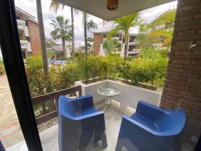 a balcony with two blue chairs and a glass table at Blue Oasis Luxury in Sosúa