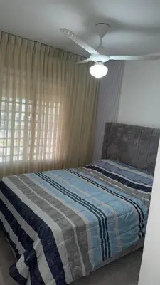 a bedroom with a bed with a blue and white blanket at New and Comfortable Apartment in Ciudad Juan Bosch in San Isidro