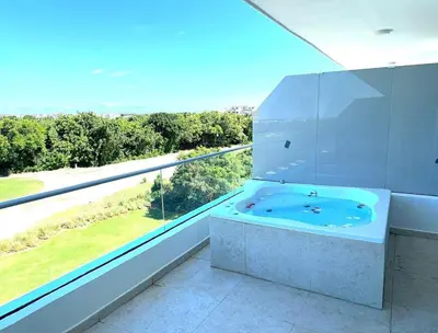 a white bathroom with a tub and a large window at New Jacuzzi Beach Fun 2 bedroom at Cana Rock Star in Punta Cana