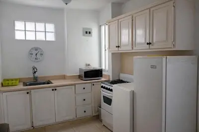 a kitchen with white cabinets and a white refrigerator at Villa La Olita in La Puntica de Juan Dolio