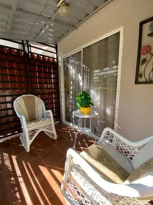 a screened in porch with two chairs and a table at Isidro 102 Comfrot Stay in San Isidro