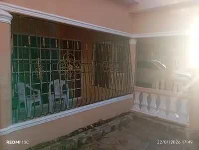 a room with a fence with a car in a window at Casa vacanza, Mendosa in Bayaguana