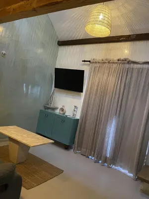 a living room with a television and a table at Mila Apartment in Bayahibe