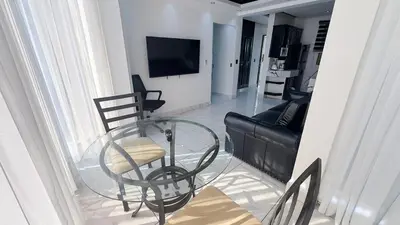 a glass table and chairs in a living room at One Bedroom Apartment - Wi-Fi - BBQ in Sosúa