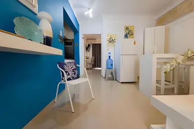 a kitchen with blue and white walls and a white chair at Los Corales Moderno Apto: Piscina y Playa 10 min in Punta Cana