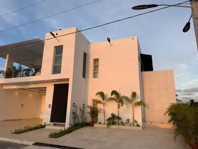 a house with palm trees in front of it at Luxurious 3-Bedroom Apartment in Juan Dolio with Pool Access in Juan Dolio