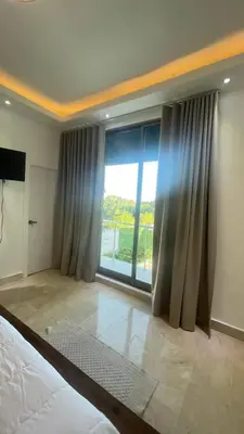 a bedroom with a large window with a view at Luxurious 3-Bedroom Apartment in Juan Dolio with Pool Access in Juan Dolio