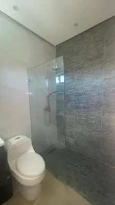 a bathroom with a toilet and a glass shower at Spacious 3-Bedroom Apartment with Pool Access in Juan Dolio in Juan Dolio