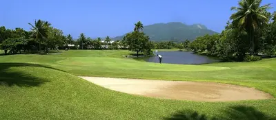 a man is standing on a lush green golf course at Bijoc 01 Apartment in San Felipe de Puerto Plata