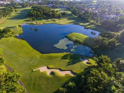 an aerial view of a golf course with a lake at Bijoc 01 Apartment in San Felipe de Puerto Plata