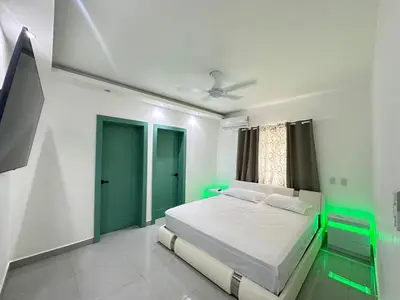 a bedroom with a bed with green lights on it at Beach front apartment in Puerto Plata