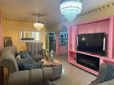 a living room with a couch and a tv at Recidencial Laurel in Baní
