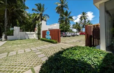 a driveway with a fence and a parking lot with palm trees at Cristamar in Cabarete
