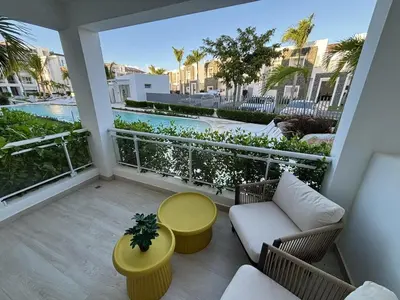 a balcony with a couch and a table at Garden Breeze Pool & Beach Escape l Bali 102 in La Laguna