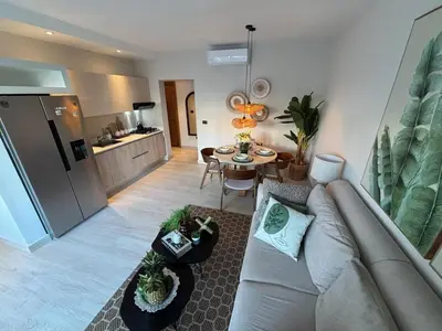 a living room with a couch and a table at Garden Breeze Pool & Beach Escape l Bali 102 in La Laguna