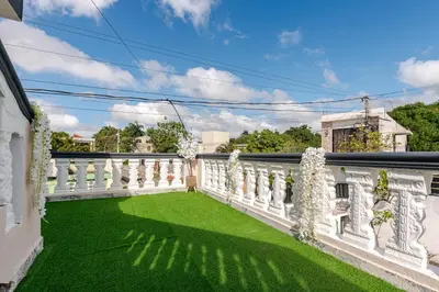 a balcony with green grass and white railing at Oz Residence Beach Two-Bedroom Apartment & Free Parking