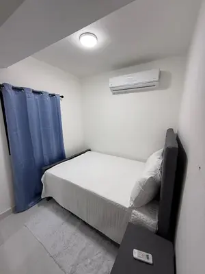 a small bedroom with a bed and a blue curtain at Moon Apartamentos C4 in San Cristóbal