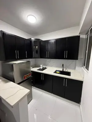 a kitchen with black cabinets and a sink at Moon Apartamentos C4 in San Cristóbal