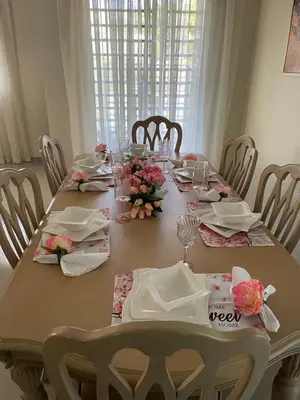 a dining table with flowers and plates on it at My Little House in Constanza