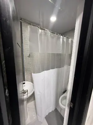 a white bathroom with a toilet and a shower at Moon Apartamentos C1 in San Cristóbal