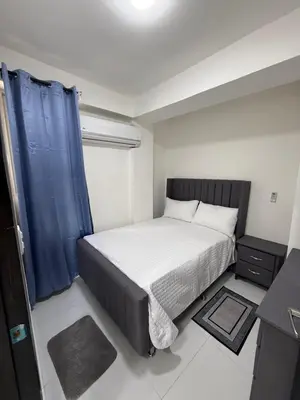 a small bedroom with a bed and a blue curtain at Moon Apartamentos D2 in San Cristóbal