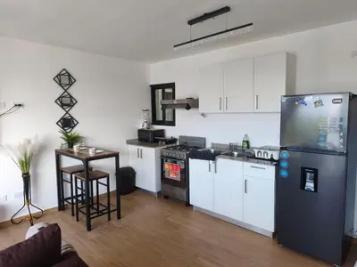 a kitchen with white cabinets and a black refrigerator at Brisa del Mar Punta Cana Apartment in Punta Cana
