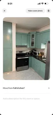 a kitchen with green cabinets and a black stove at Lissette altagracia in Concepción de La Vega