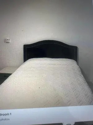 a white bed with a black headboard in a room at Lissette altagracia in Concepción de La Vega