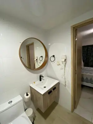 a white bathroom with a sink and a mirror at Departamento en la playa de palenque in Sabana Grande de Palenque