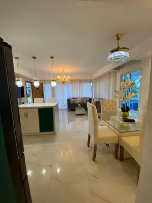 a kitchen and living room with a table and a couch at Departamento en la playa de palenque in Sabana Grande de Palenque