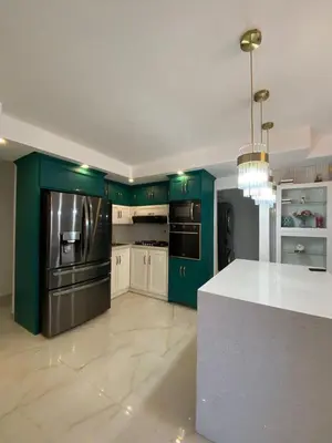 a kitchen with green cabinets and a white counter top at Departamento en la playa de palenque in Sabana Grande de Palenque