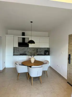 a dining room with a table and some white cabinets at Luz y paz