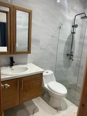 a bathroom with a toilet and a glass shower at Tropical oasis rentas in Las Terrenas