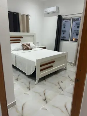 a bedroom with a white bed and a mirror at Tropical oasis rentas in Las Terrenas