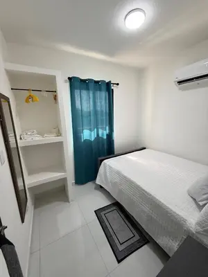 a bedroom with a bed and a blue shower curtain at Moon Apartamentos D3 in San Cristóbal