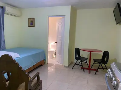 a bedroom with a bed and a table and chairs at Nido del patio, 40 min to Bocachica beach 5 center in La Piedra