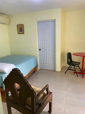 a bedroom with a bed and a chair and a table at Nido del patio, 40 min to Bocachica beach 5 center in La Piedra