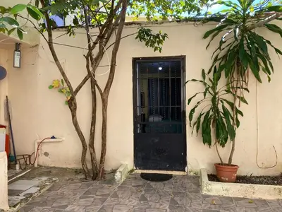 a black door in the side of a building with two trees at Nido del patio, 40 min to Bocachica beach 5 center in La Piedra