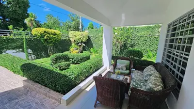 a balcony with a garden with bushes and chairs at Casa campo Ana Victoria