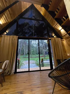 a room with a large window in a cabin at Cabaña Silencio Verde in Jarabacoa