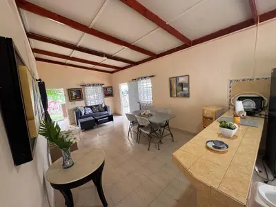 a living room with a table and a dining room at Casa de campo El Bonao in Higuey
