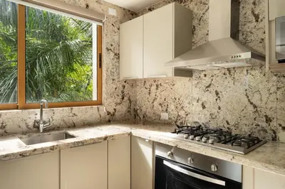 a kitchen with a sink and a stove and a window at Luxury 3BR Penthouse in Casa de Campo, Gated Resort Living & Golf View in La Romana
